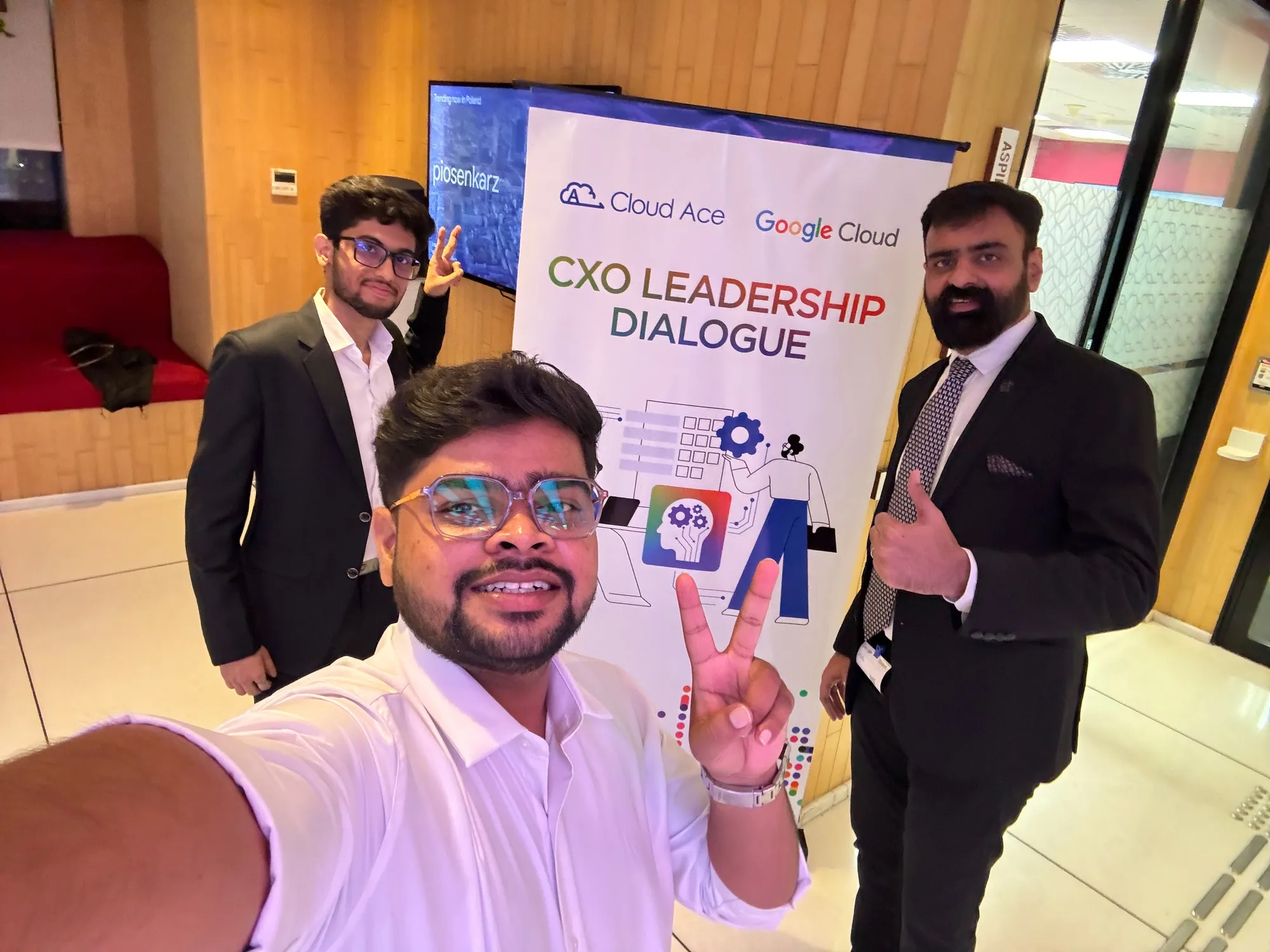 Event team members taking a selfie beside the CXO Leadership Dialogue banner, co-branded by Cloud Ace and Google Cloud