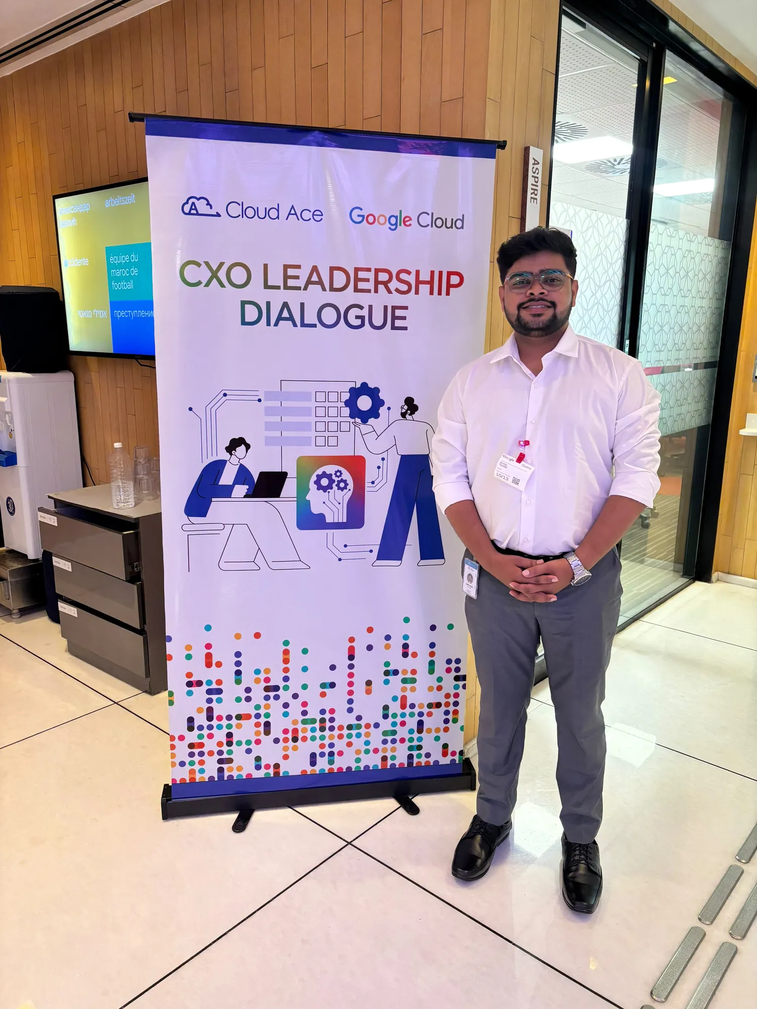 An event team member standing beside the CXO Leadership Dialogue banner