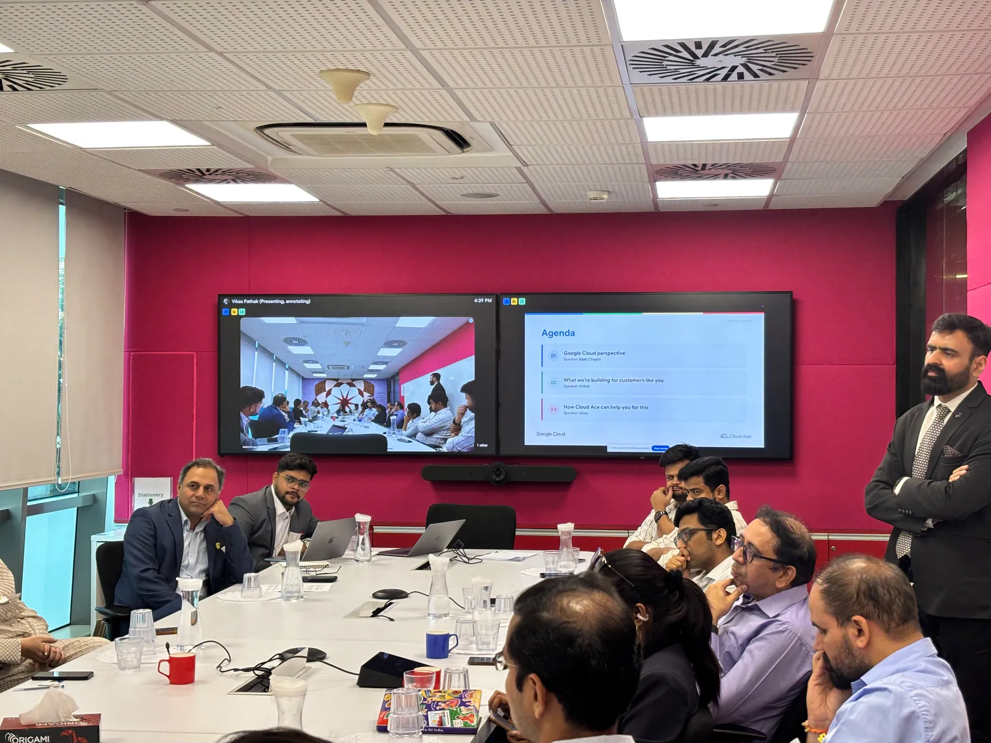 Wide view of the boardroom at the Google Gurgaon office, with business leaders seated around a long table, the session agenda on two large screens and a host standing at the right